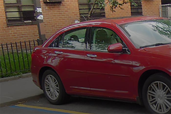 Red car parked in front of building